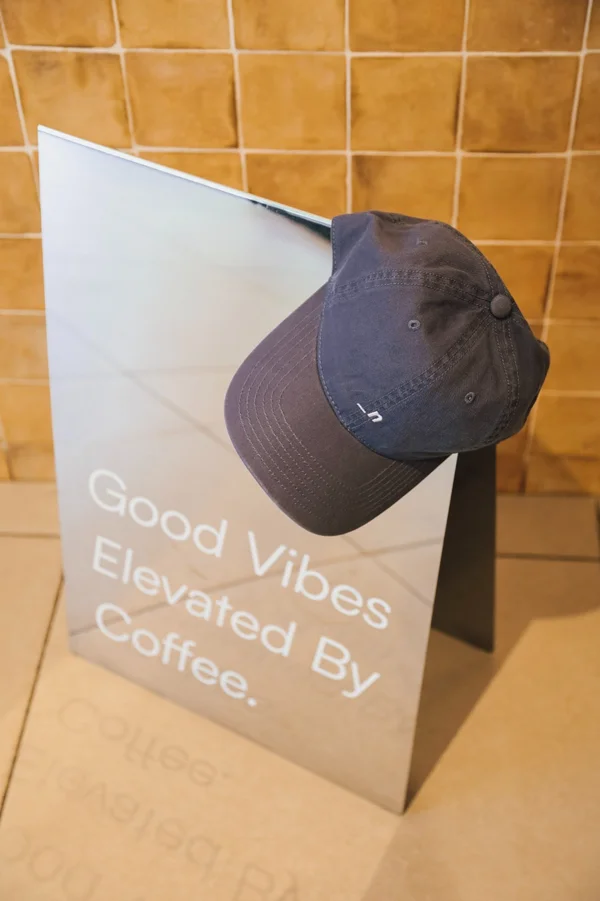 Noia Coffee cap on Good Vibes Elevated By Coffee sign with warm terracotta tiles
